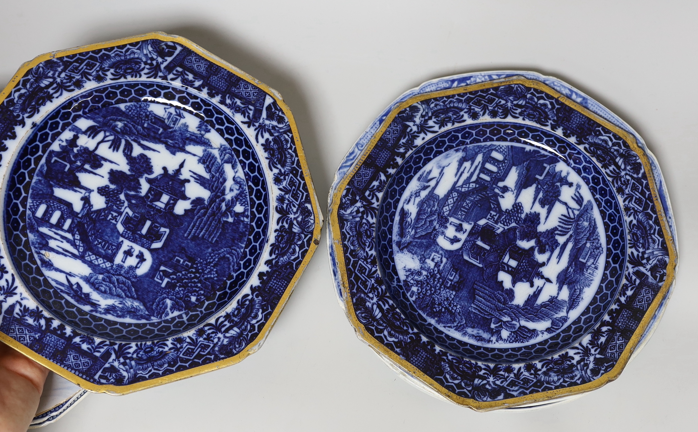 A collection of pearlware blue and white plates and two tea canisters, c.1790-1810, A Worcester Hollow Rock pattern saucer and an English delftware plate painted with Chinese figures, 23cm diameter